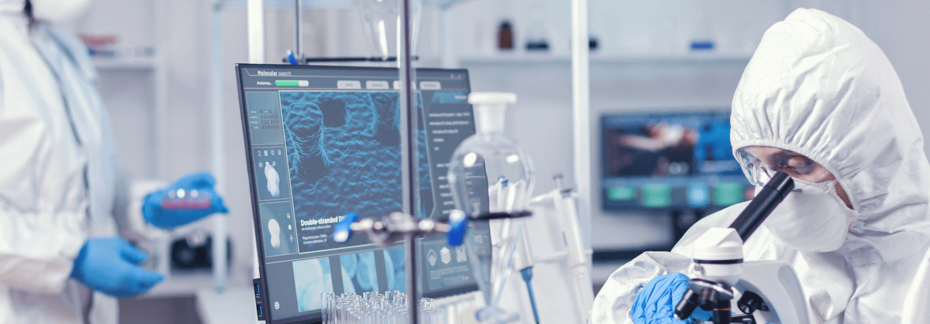 Laboratory scientist using a microscope with advanced diagnostic displays